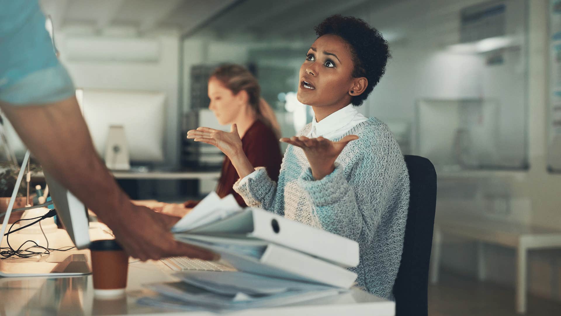 woman in blue shirt looking up at coworker as she says what do you want me to do about it