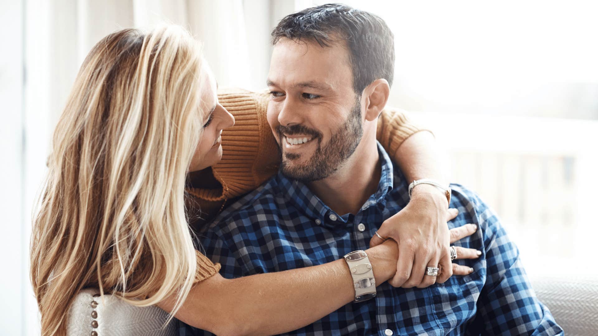 woman with blonde hair hugging man as they're protective of the people they care about
