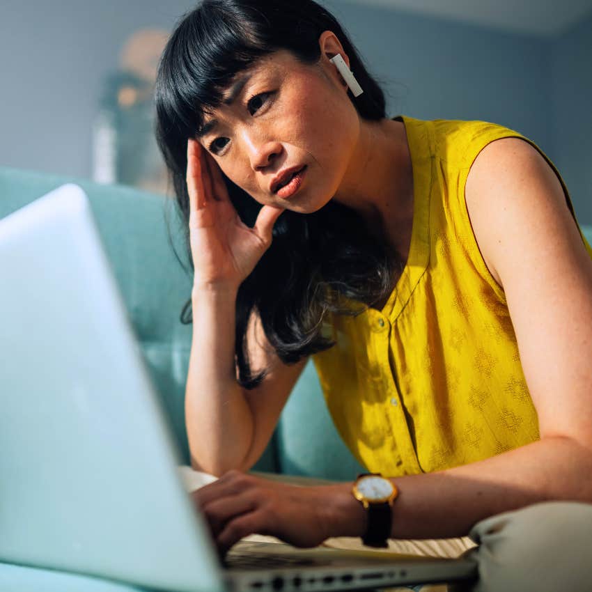 unhappy stressed woman working on laptop telling herself I just need to get through today