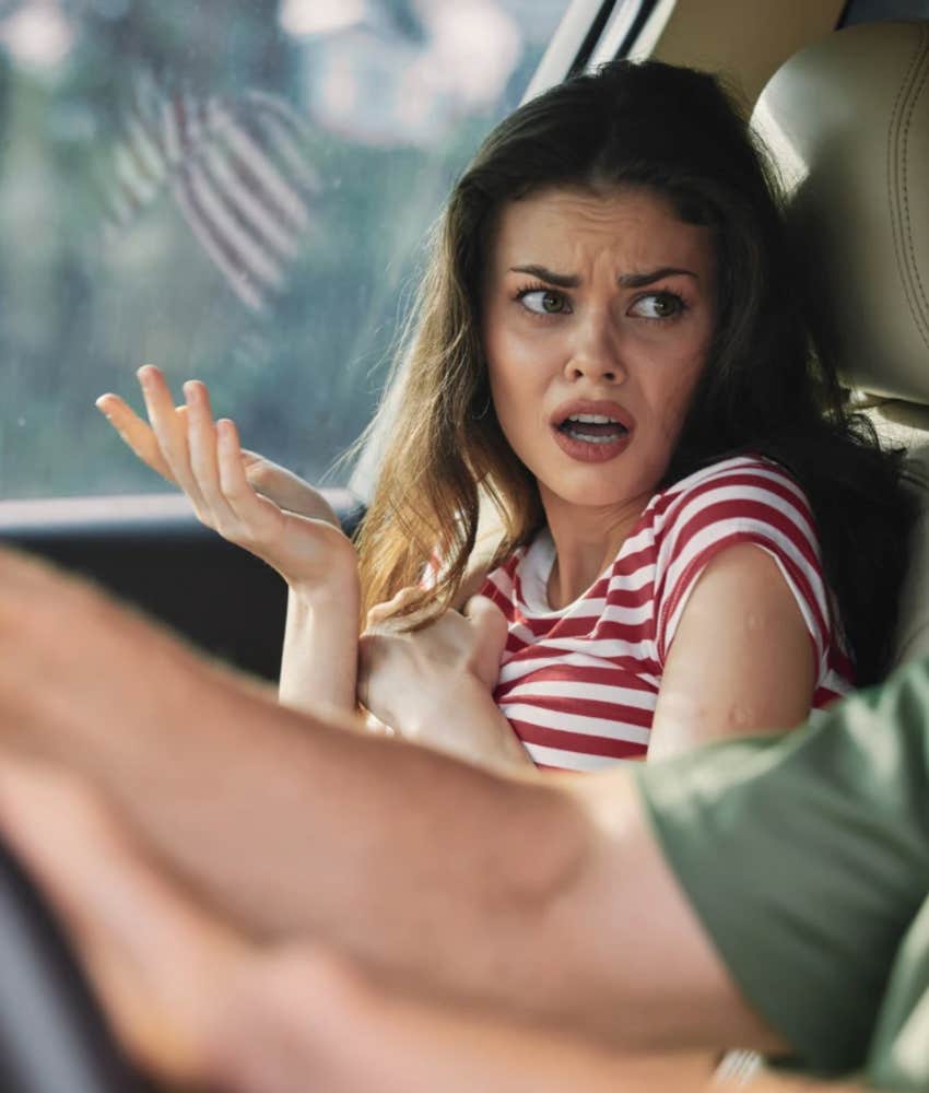 emotionally mediocre woman shrugging in a car