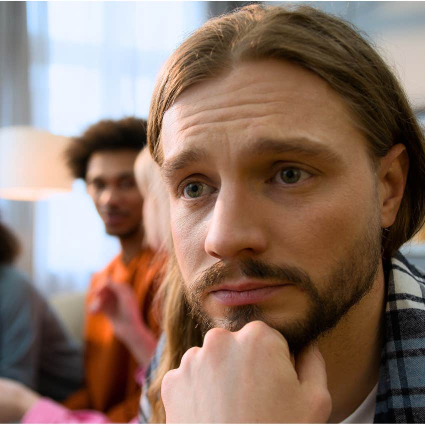 upset man reading into people's energy in a group