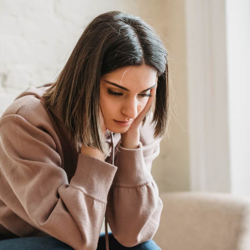 woman who seems sad with head in hands 