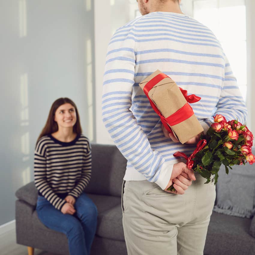 man surprising his partner with a gift and flowers