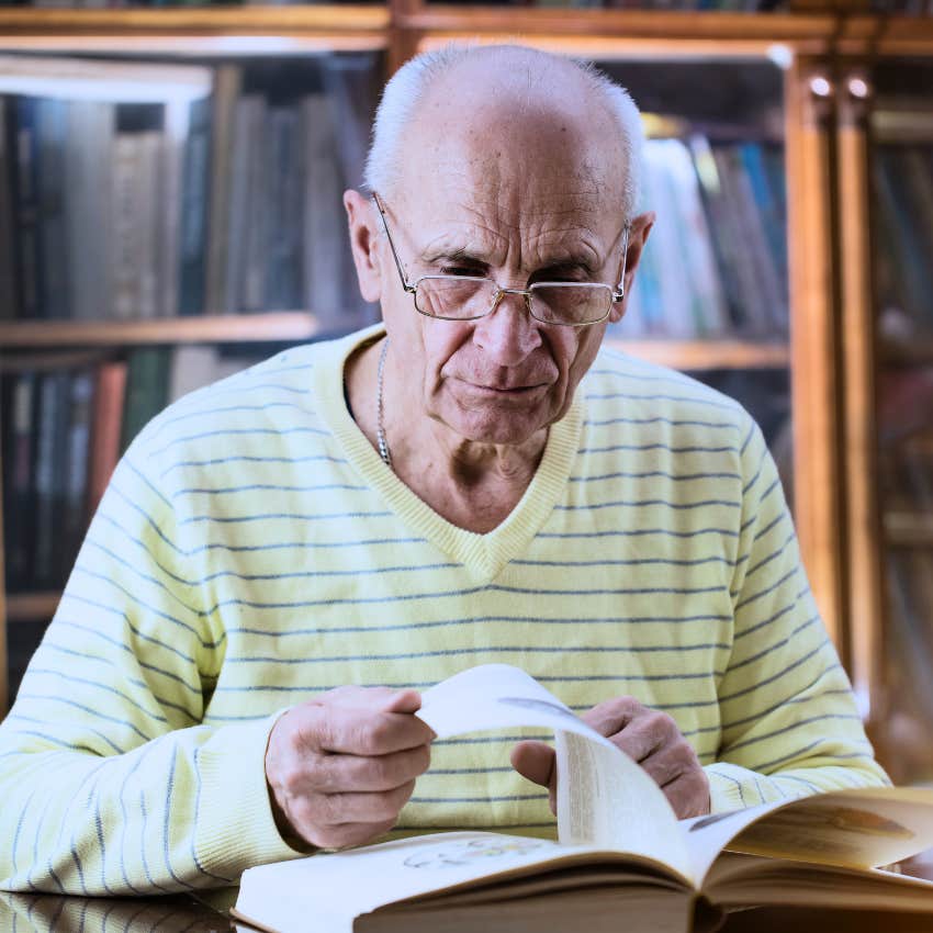 Man with outdated physical phone books in his home.