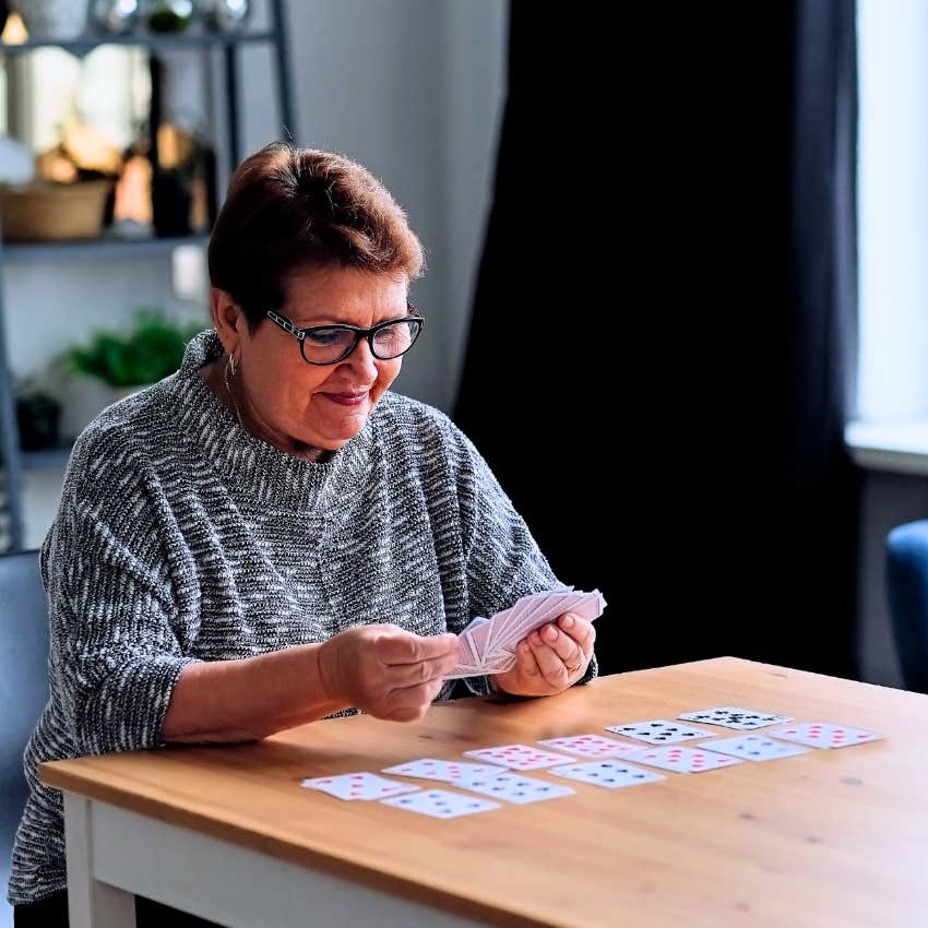 Woman who enjoy alone time playing cards.