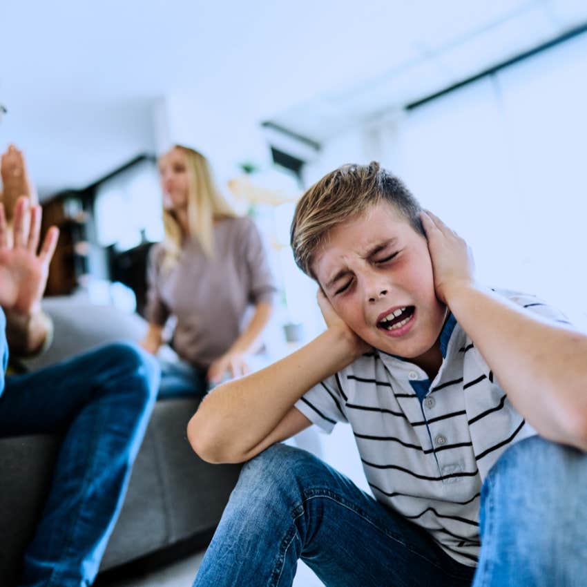 boy covering his ears sensitive to rejection with arguing parents