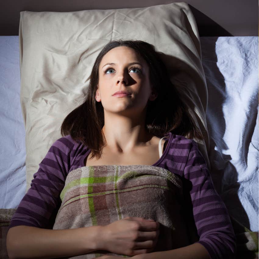 woman having trouble sleeping lying awake in bed