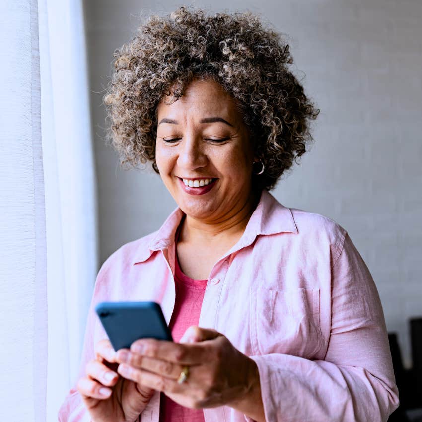 happy woman texting why not on her phone smiling