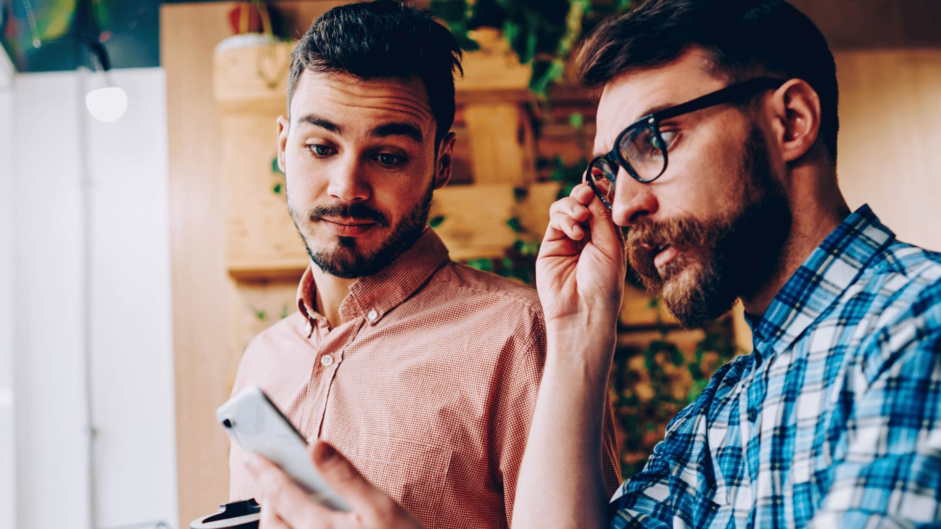 man losing his capacity for bad news showing friend his phone saying i try not to look