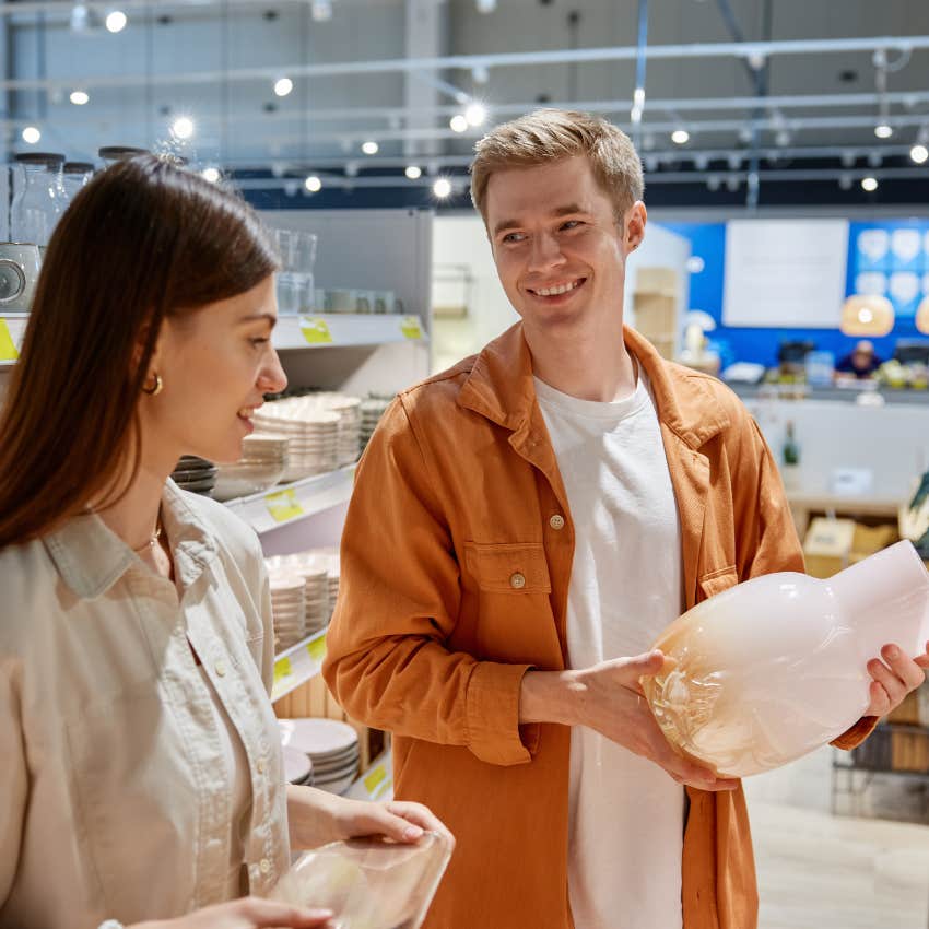 woman refusing to buy decorative vase her boyfriend wants her to get