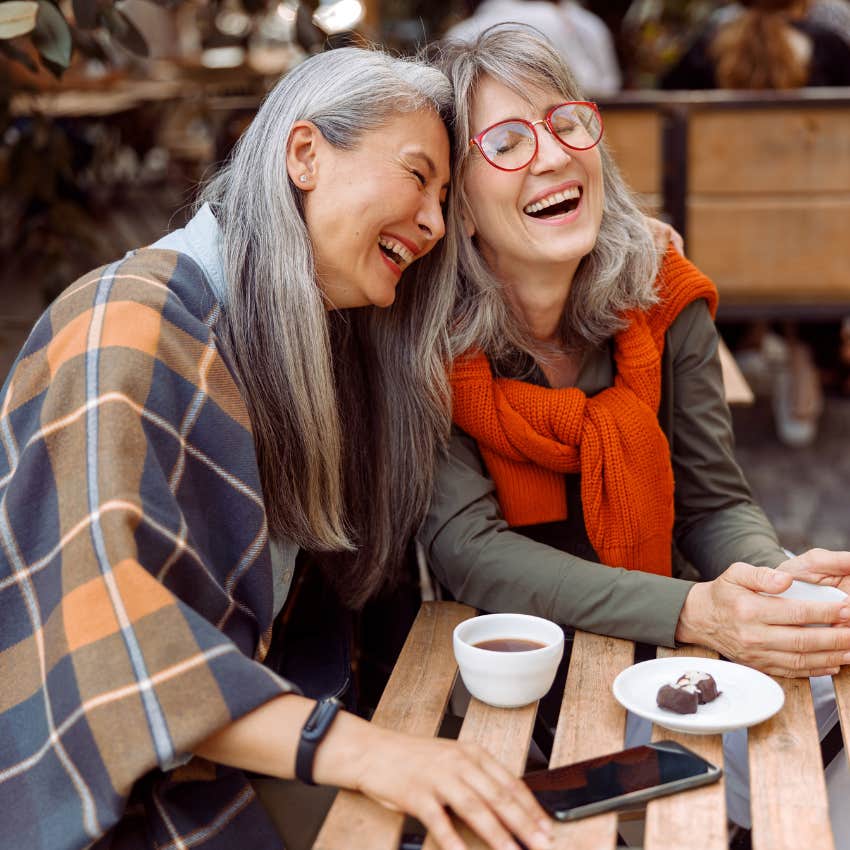 two women over 60 laughing and having fun because they know aging is not a curse