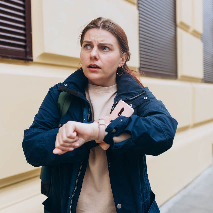 emotionally drained woman looking at watch because she overbooked her weekend