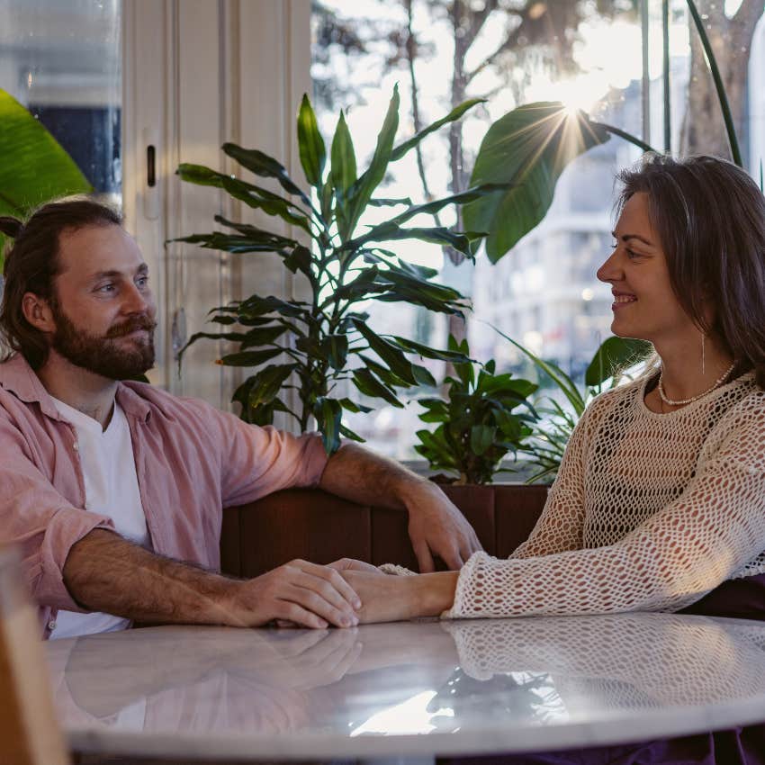 emotionally deep man sharing personal experiences with girlfriend while holding her hand