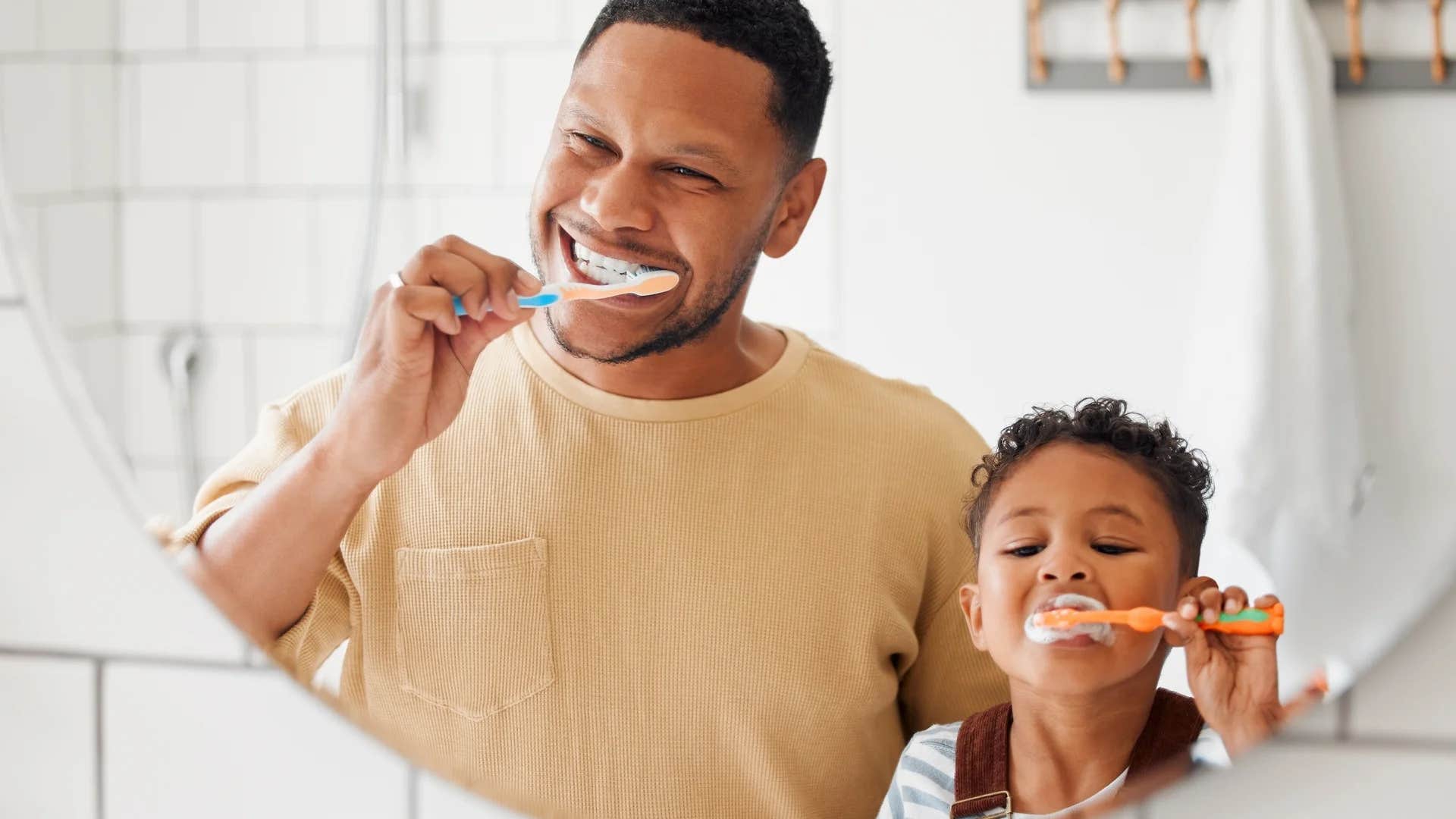 dad helping son set a consistent routine brushing their teeth