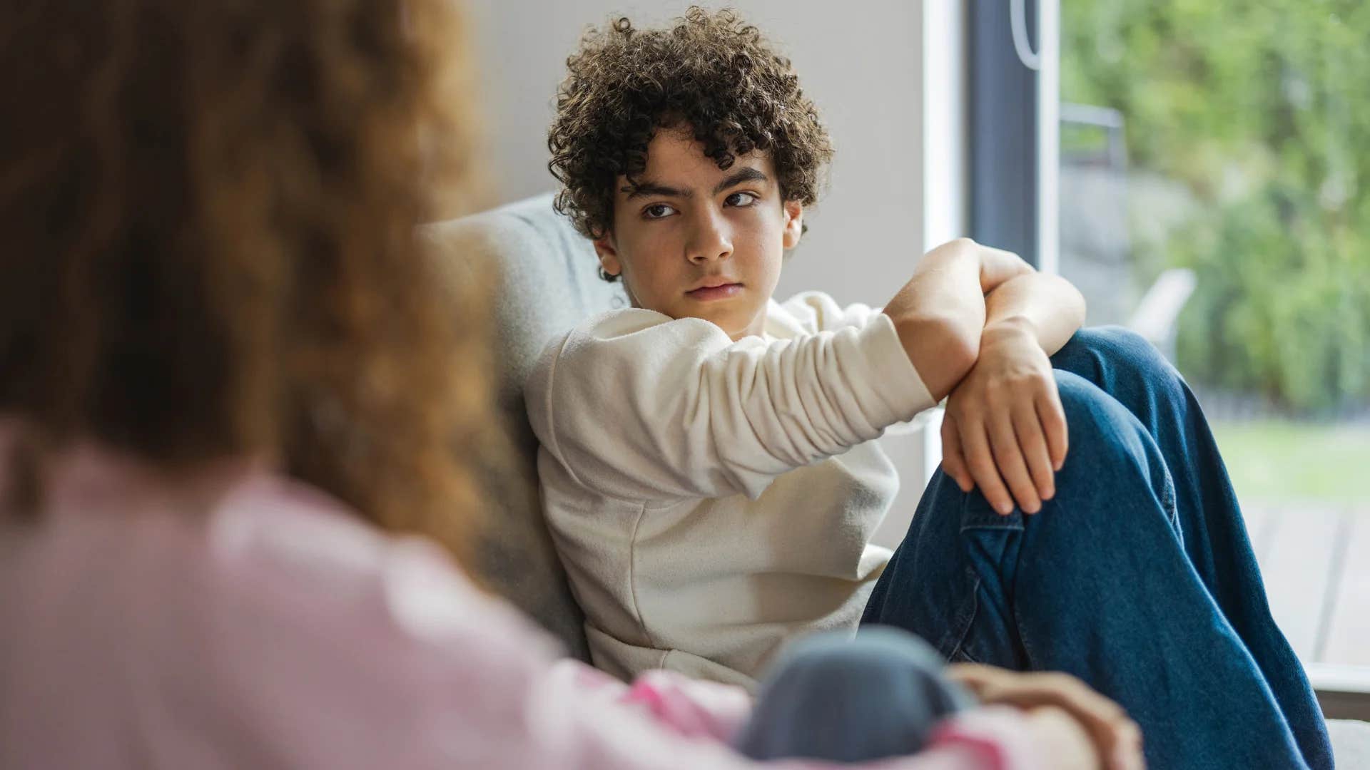 mom sitting down with son not buying him whatever he asks for