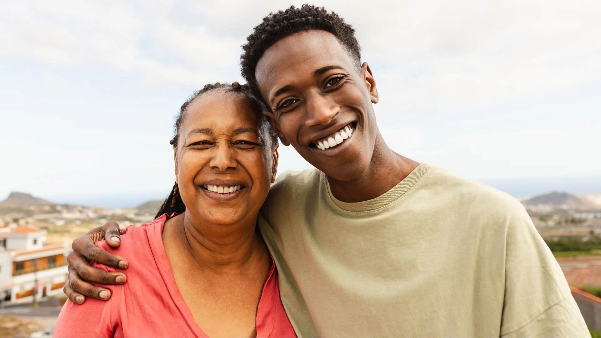 young man hugging his happy grandmother side by side