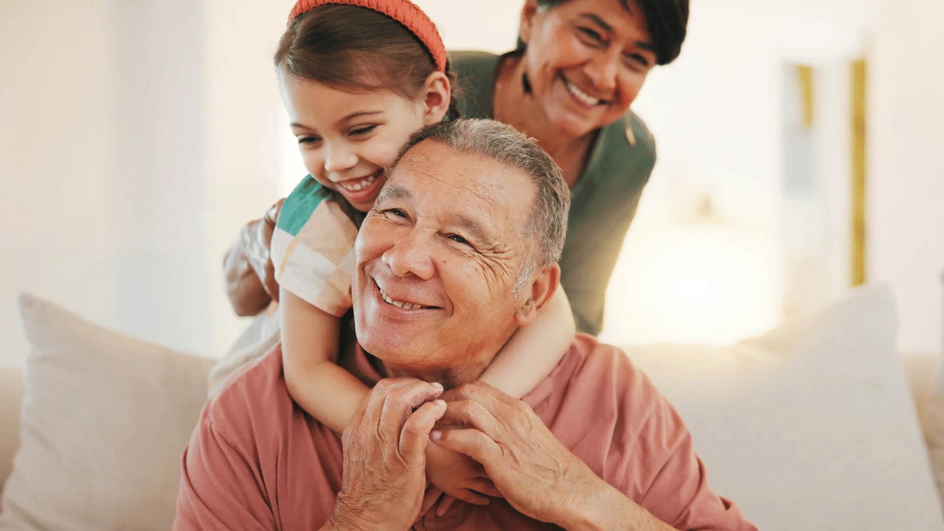 grandfather smiling while babysitting his granddaughter