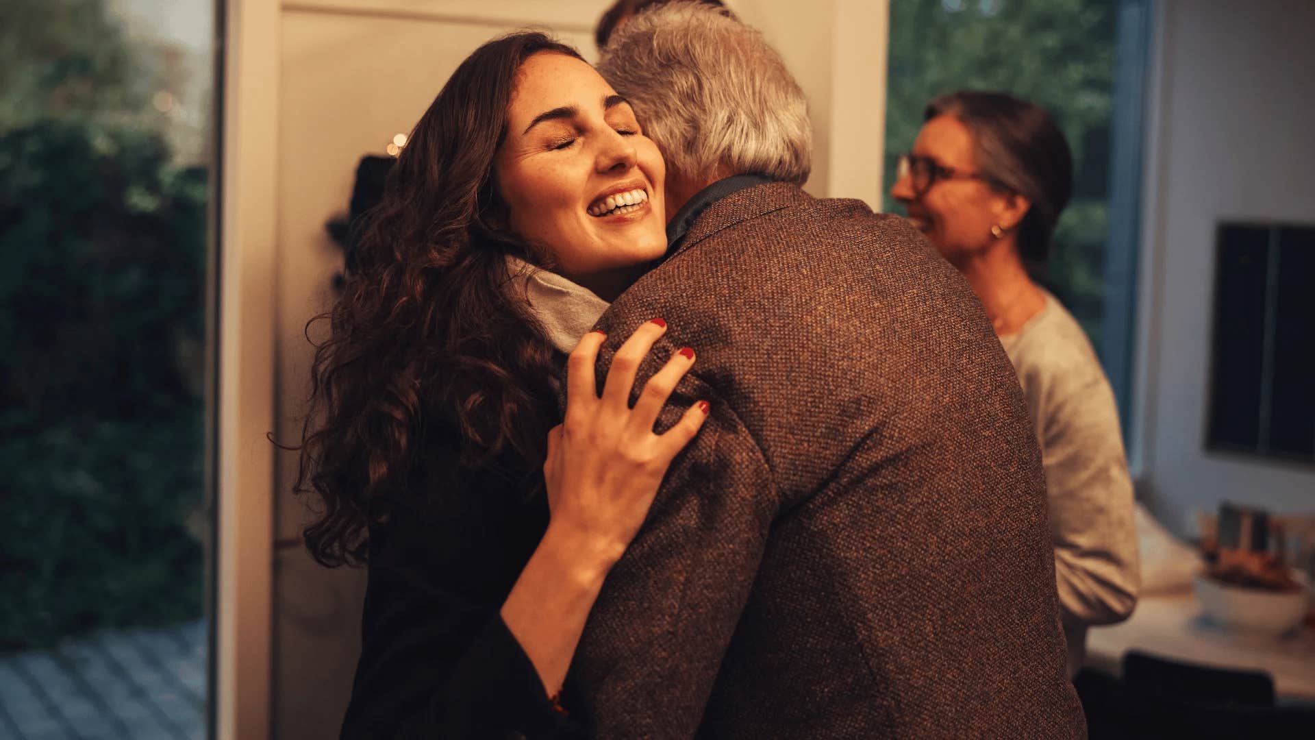 young woman hugging her grandfather at family event