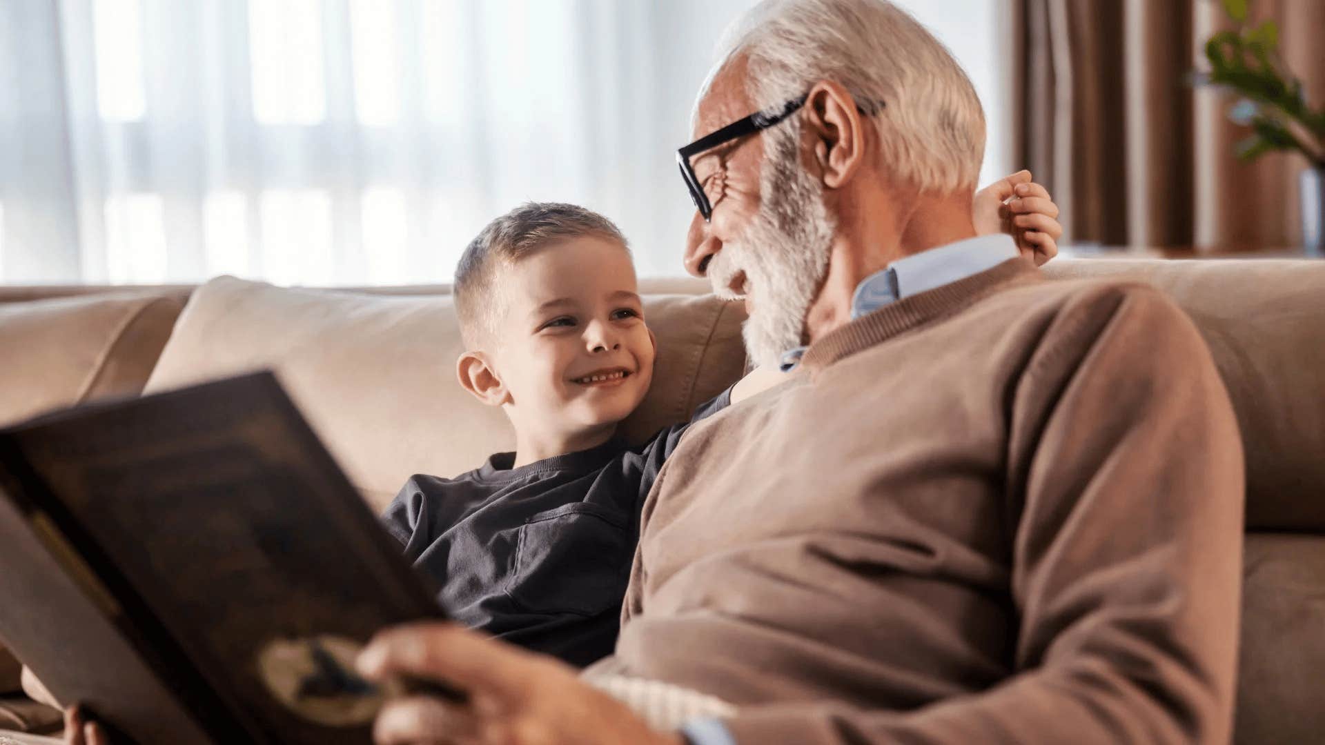 grandfather teaching his grandson important life skills reading him a book
