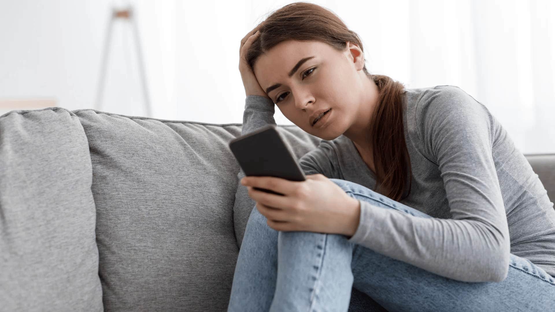 socially anxious intelligent woman worried looking at phone
