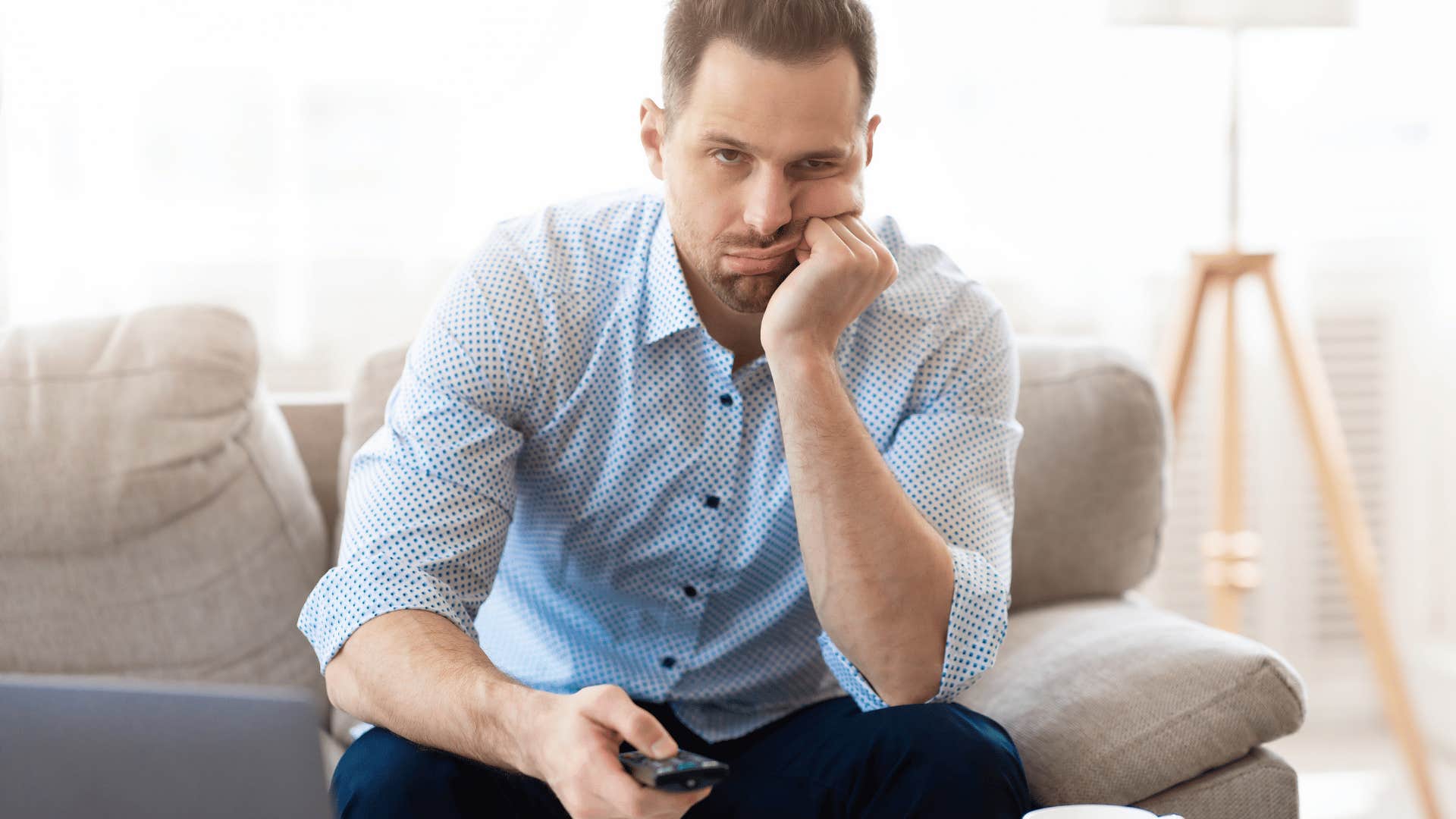 man in blue shirt upset as he has to pay a monthly fee to watch tv