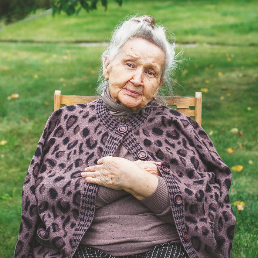 older woman sitting outside wearing dated clothing