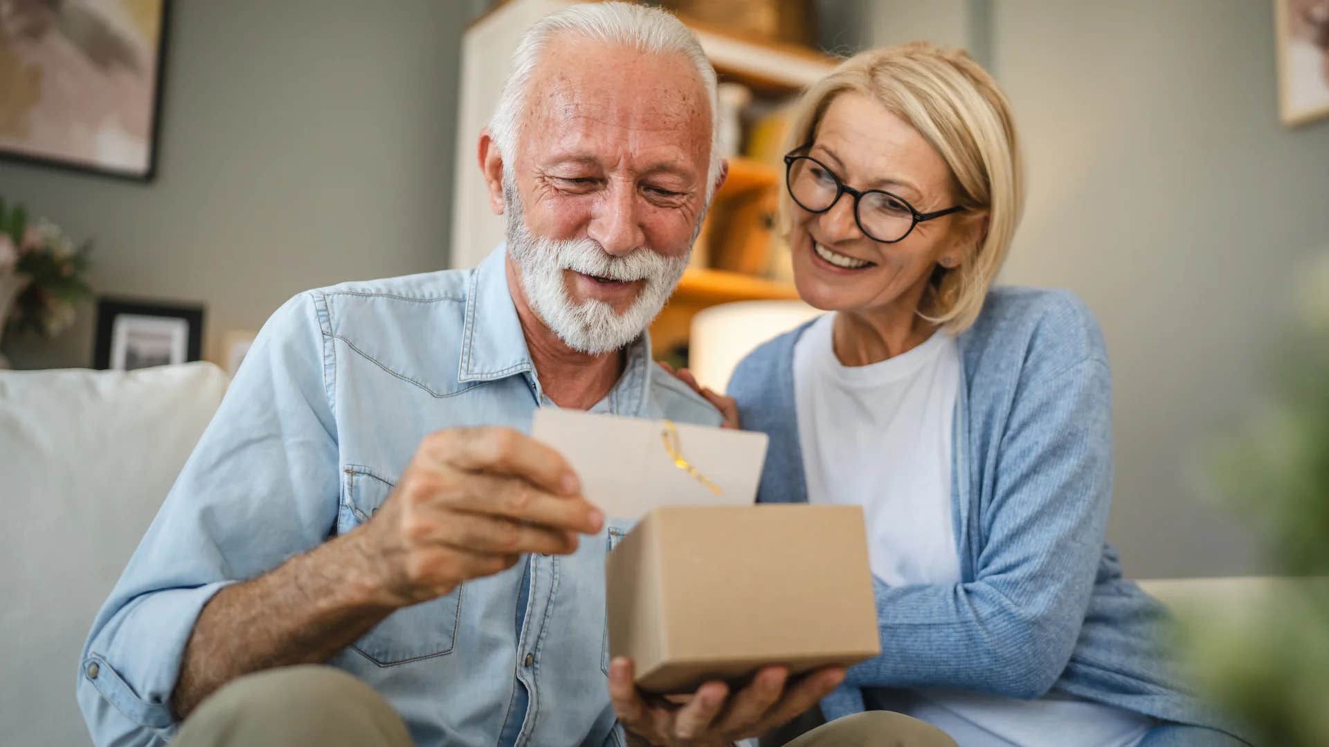 boomer couple smiling looking at greeting cards to send