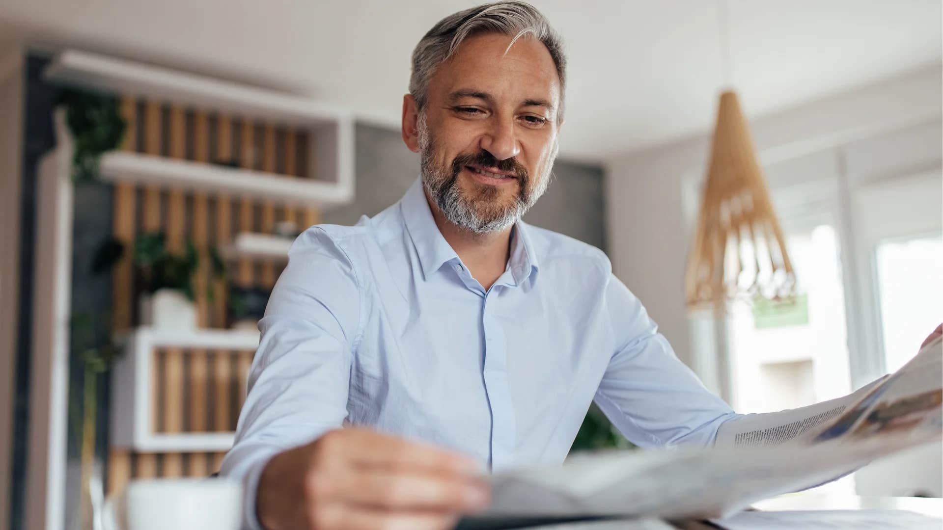 gen X man reading print newspapers at home