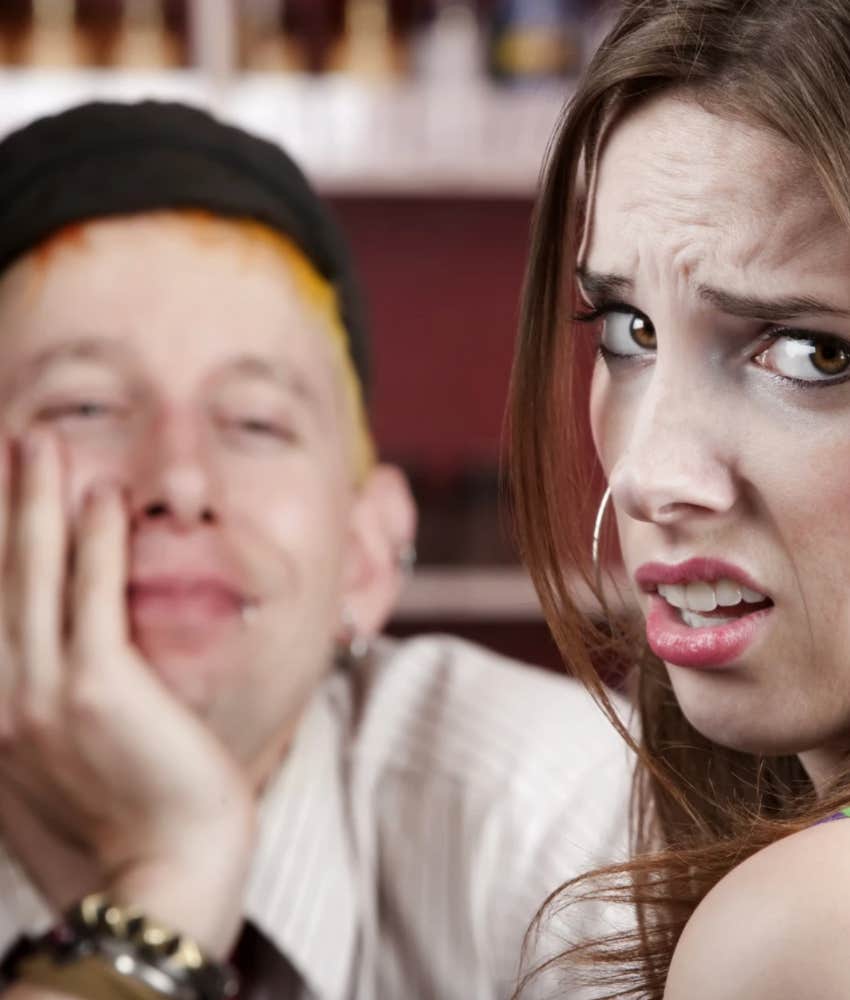 woman who seems annoyed and emotional looks away from smiling man