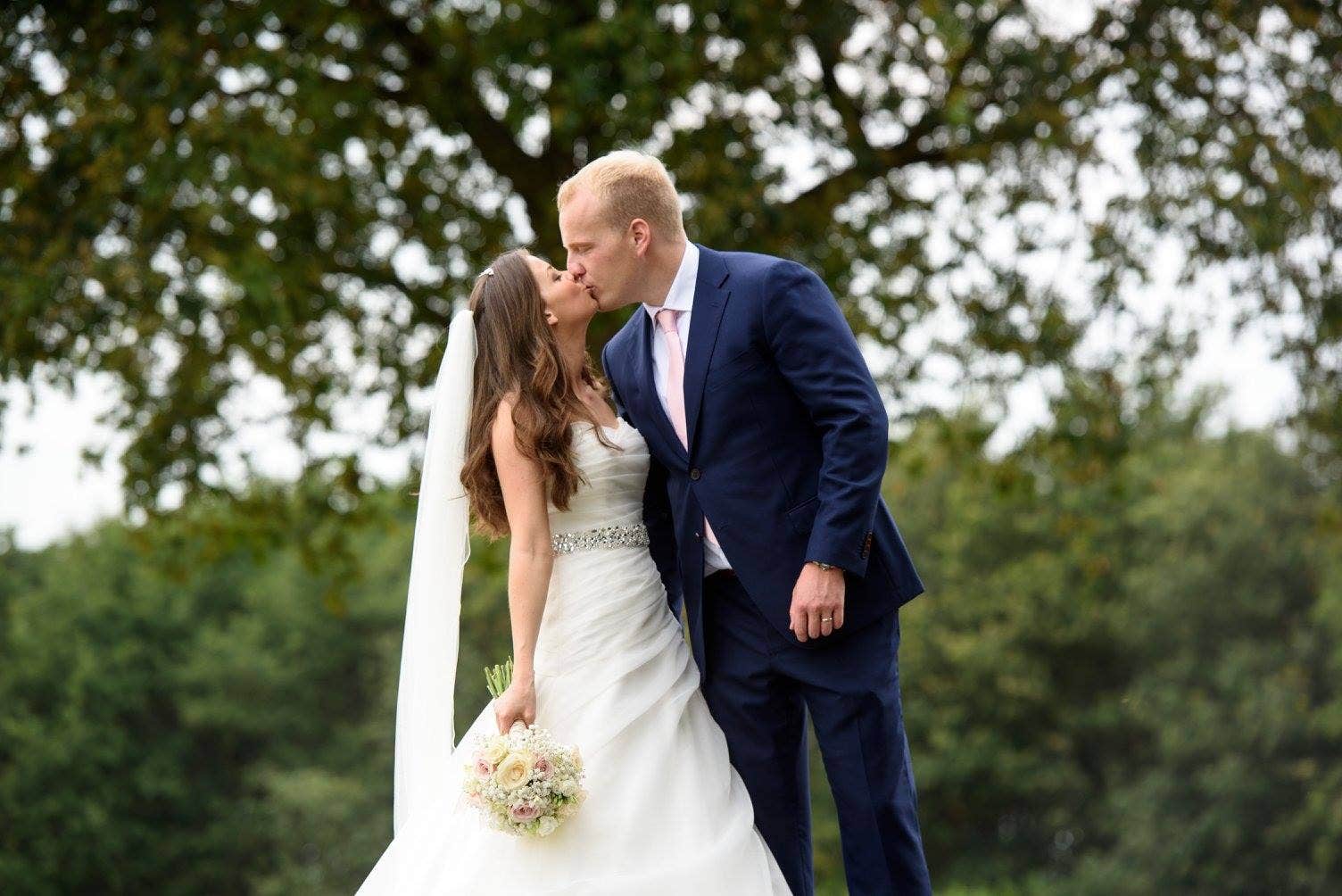 A bride and groom kissing on the wedding day 