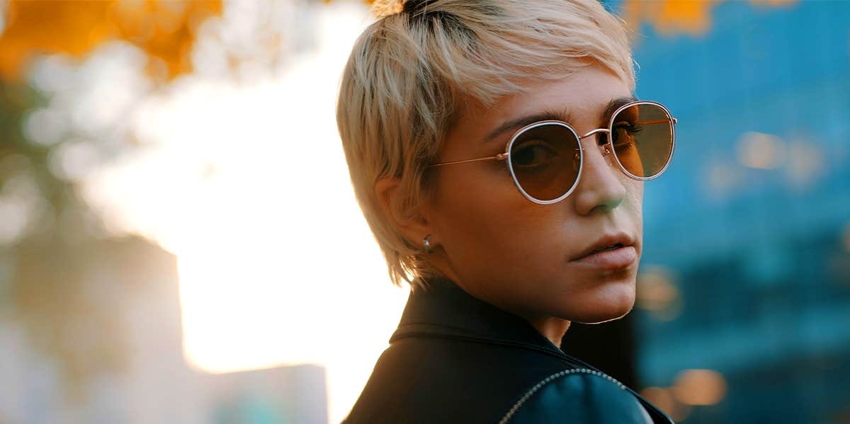 Lies Women Need To Stop Telling Themselves (If They Want To Get Ahead) woman in sunglasses looking over shoulder