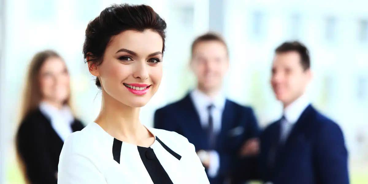 professional woman with coworkers behind her