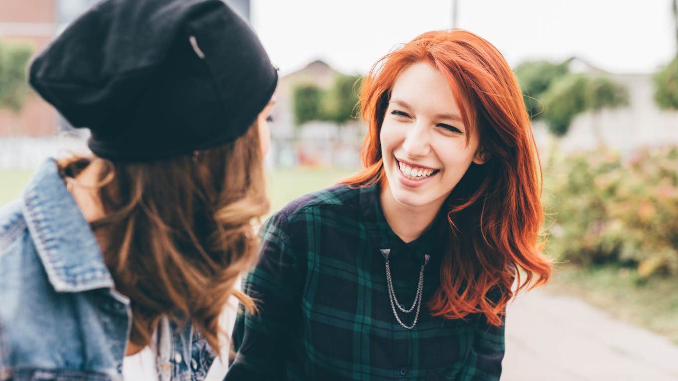 two women talking and laughing outside