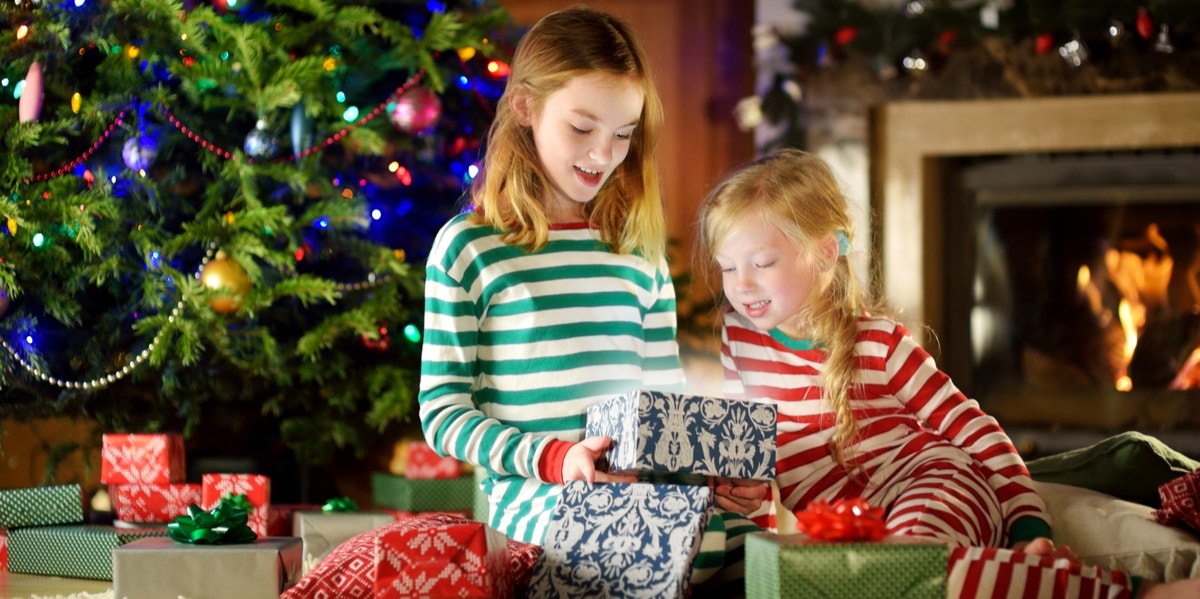 3 Scary Reasons Not To Give Your Kids Too Many Presents sisters opening christmas presents