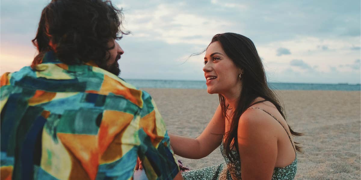 couple sitting on the beach talking