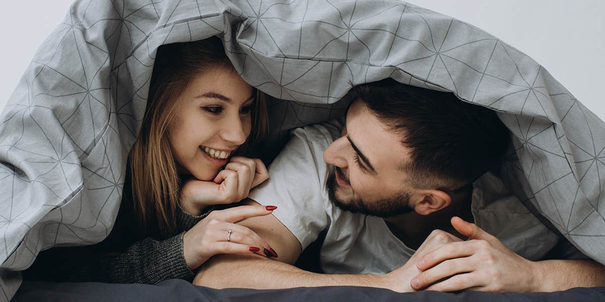 3 Ways To Make Sure He Knows You Dig Him couple cuddling under covers
