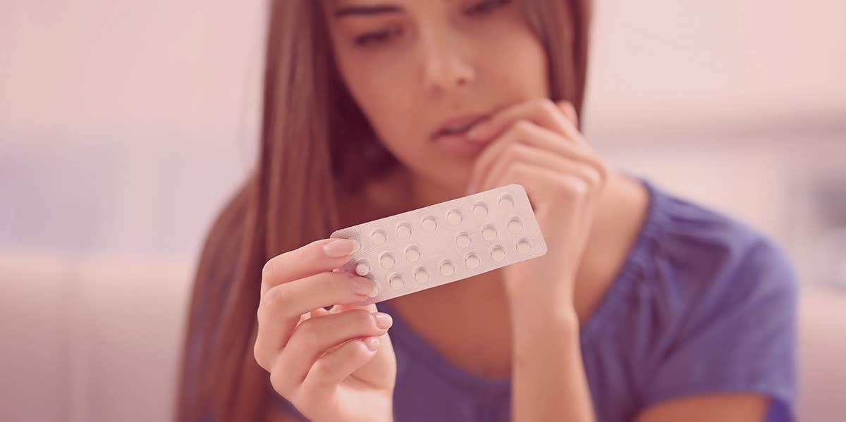 3 Ways The Birth Control Pill Messes With Your Body woman holding up birth control pills