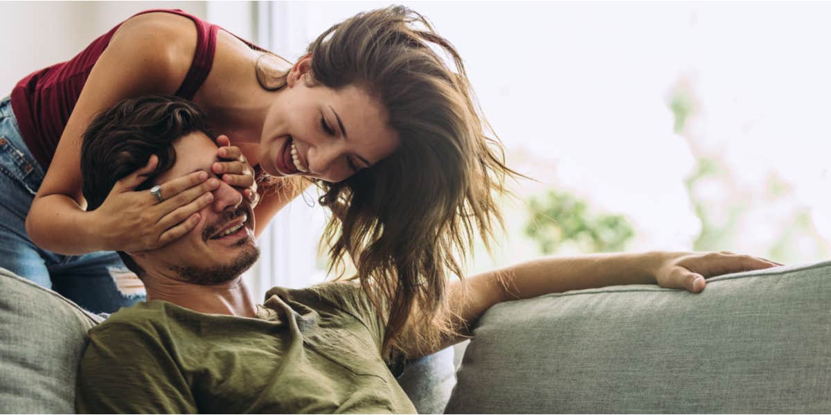 woman covering man's eyes for surprise