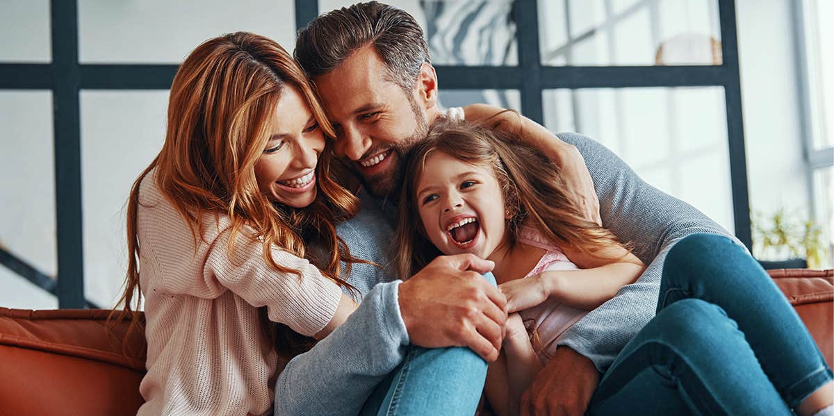 family laughing together parents and young daughter