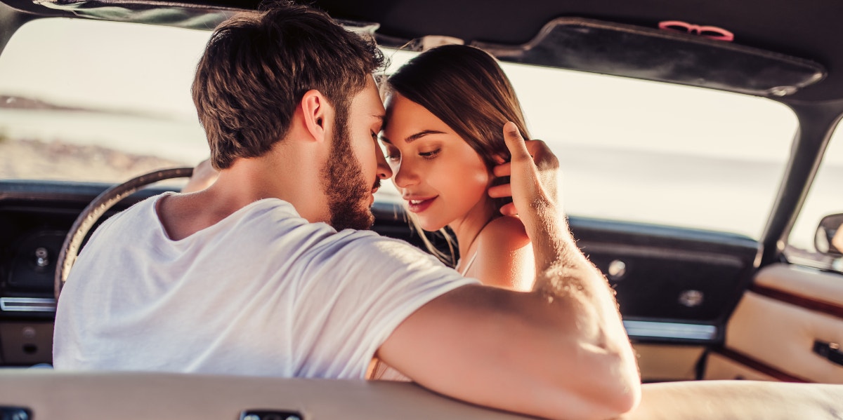 Man and woman kiss in car