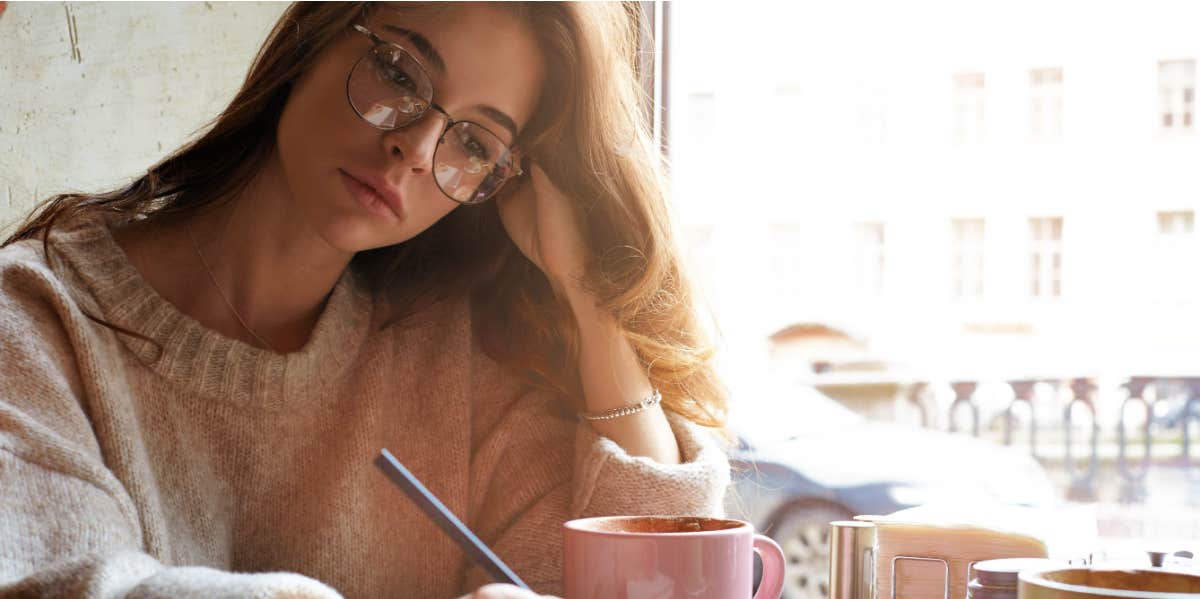 girl in glasses writing in notebook