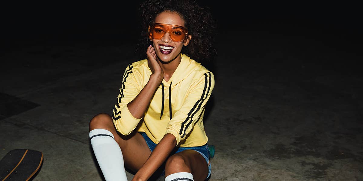 girl sitting near skateboard at night