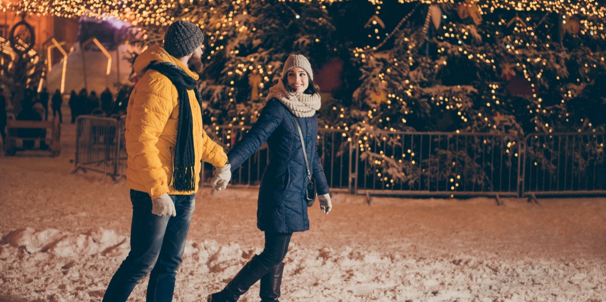 man and woman walking in snow