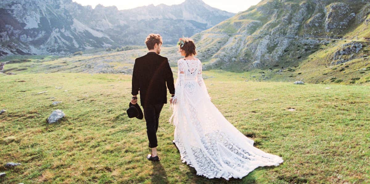 bride and groom walking in field