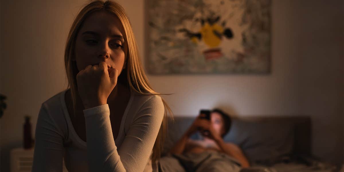 unhappy woman sitting in bedroom