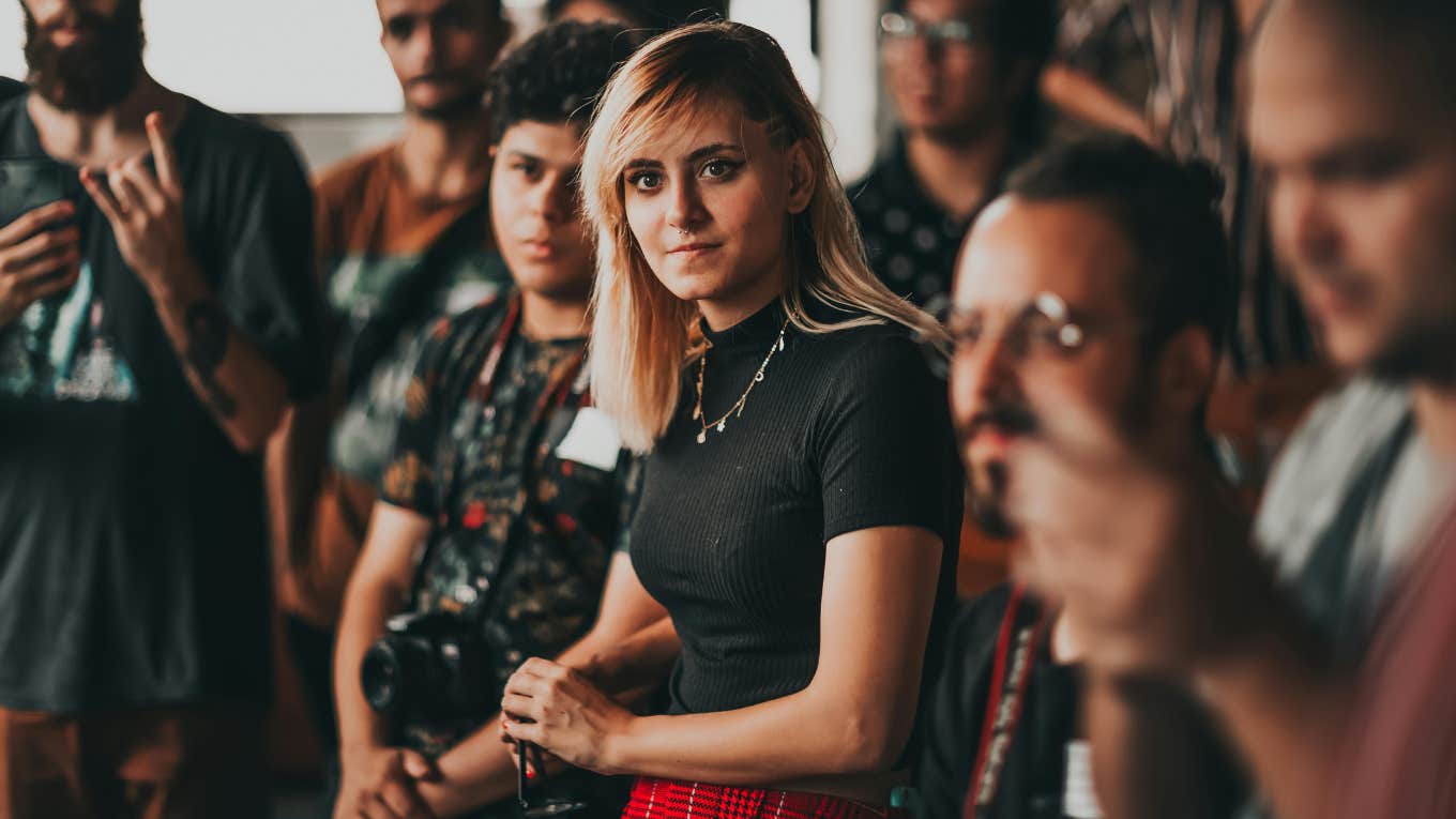 young woman in a room of people