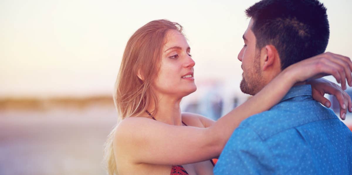 woman hugging man on beach