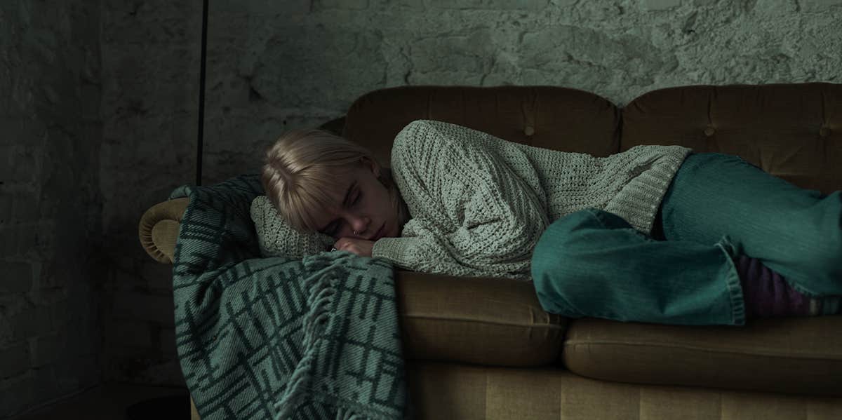 depressed woman laying on couch