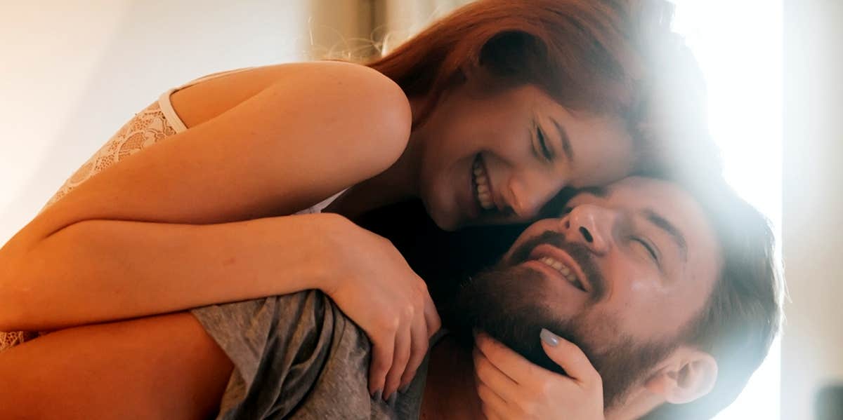 smiling couple cuddling in bed