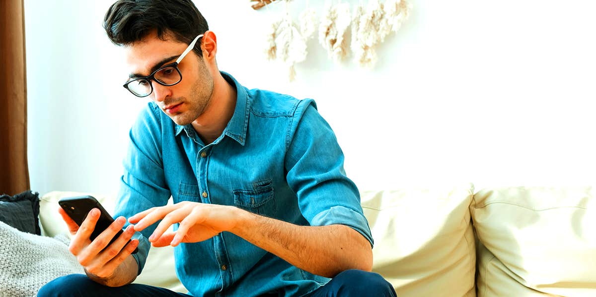 guy sitting on couch texting on phone